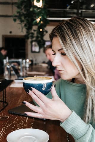 A Lady Drinking Coffee while Using ATLRx Products